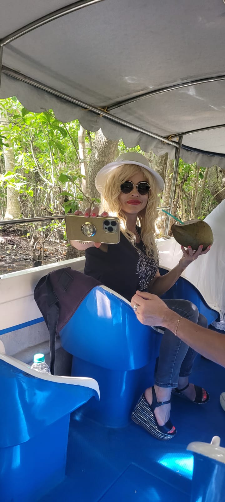 Guest taking a selfie with a coconut on the boat
